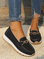 Angled view of navy denim loafer pair showing contrast tan heel panel