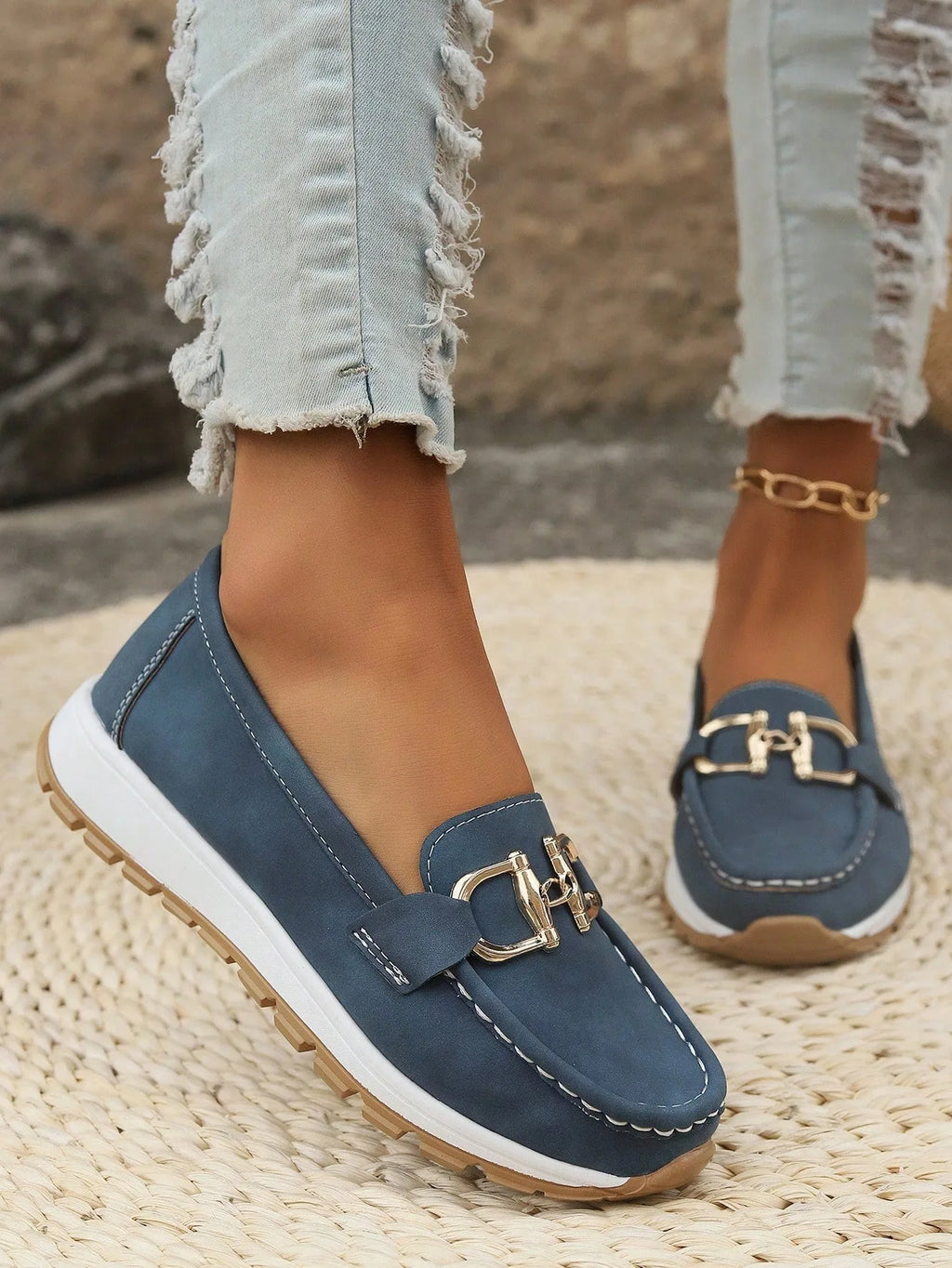 Top-down view of cream loafer pair on decking showing rounded toe shape