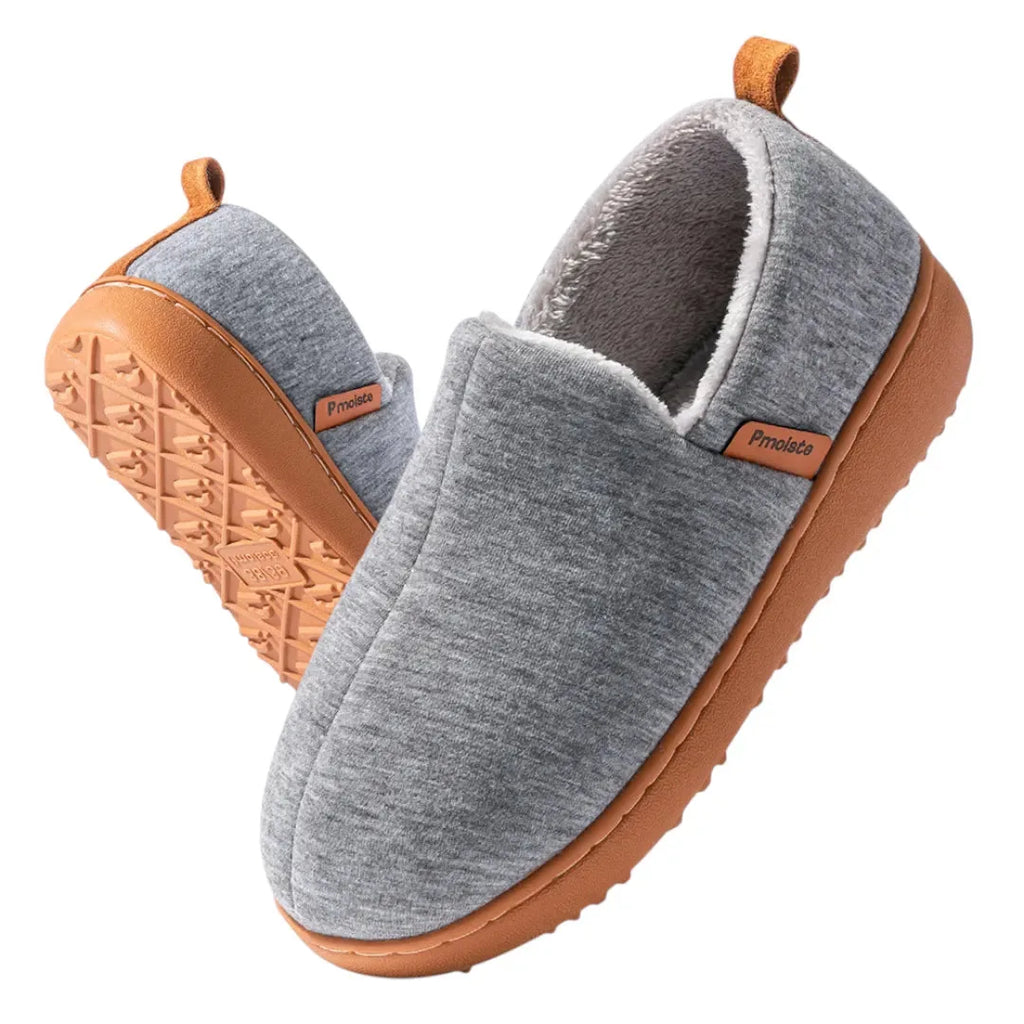 Close-up of the textured tan rubber outsole on a dark grey fleece lined slip-on slipper