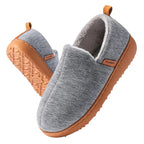 Close-up of the textured tan rubber outsole on a dark grey fleece lined slip-on slipper