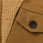 Close-up of the khaki fabric with a chest pocket flap, button detail and sherpa lining visible