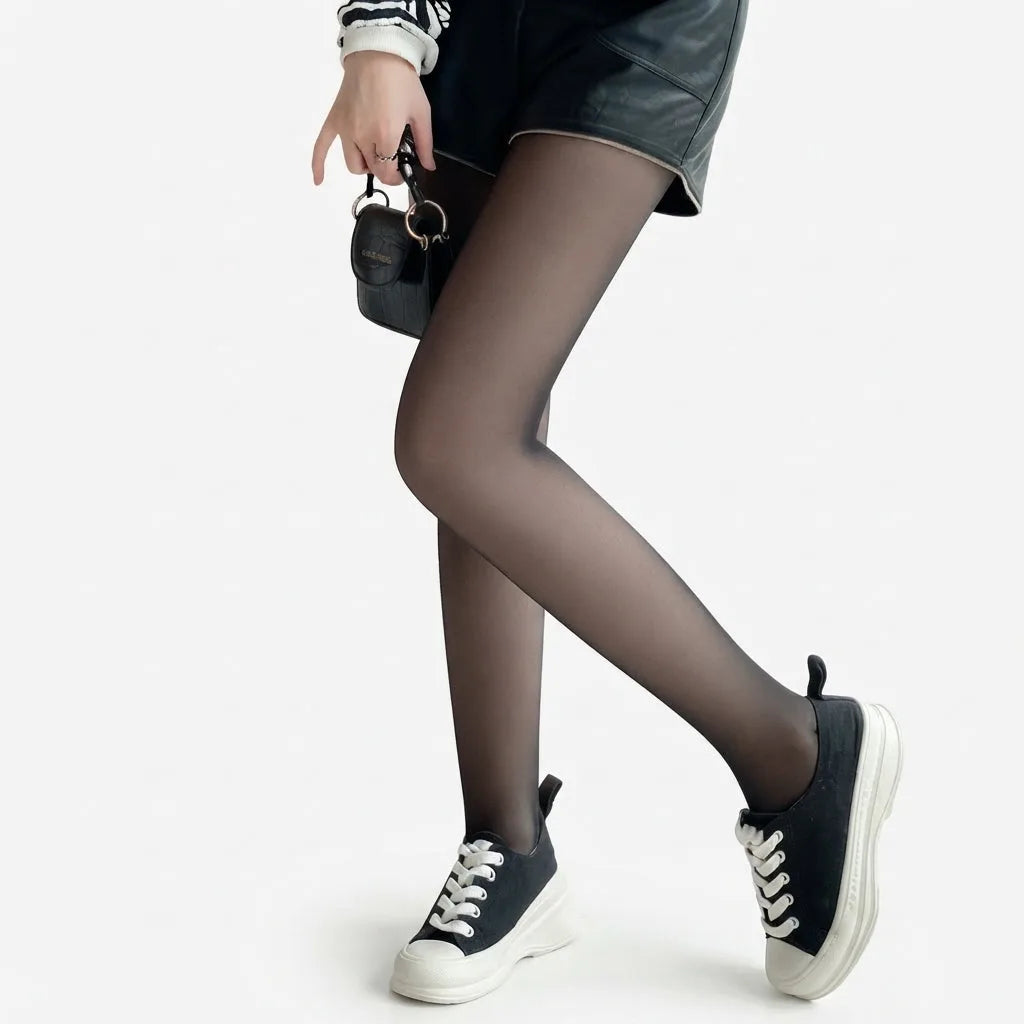 Side view of sheer black tights with a leather-look skirt, mini bag and black platform trainers