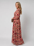 Side profile of pink floral maxi dress showing long sleeves, tiered hem and flowing silhouette