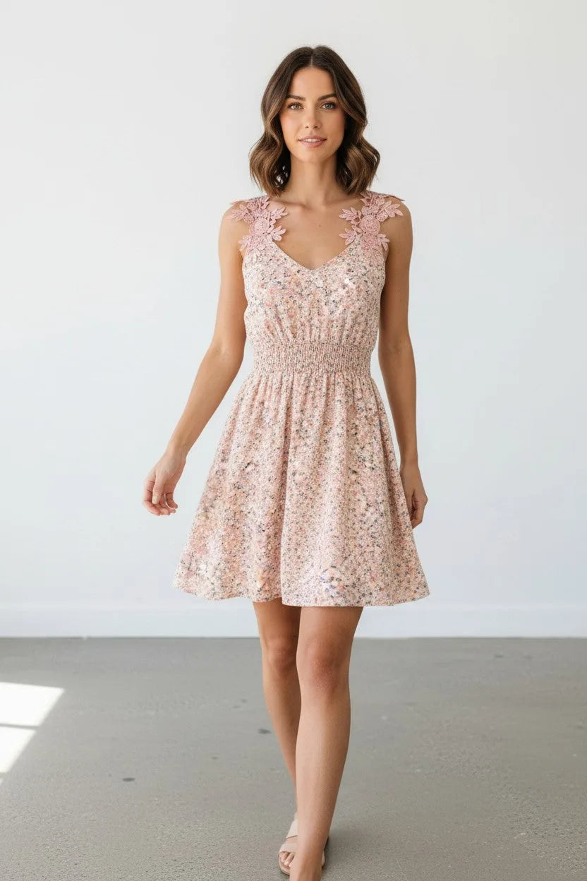 Front view of woman wearing a pink floral sequin mini dress with lace shoulder straps and V-neckline