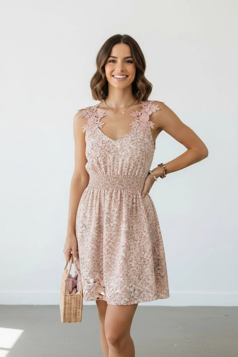 Smiling woman modelling the sleeveless floral mini dress with lace strap detail and layered necklace