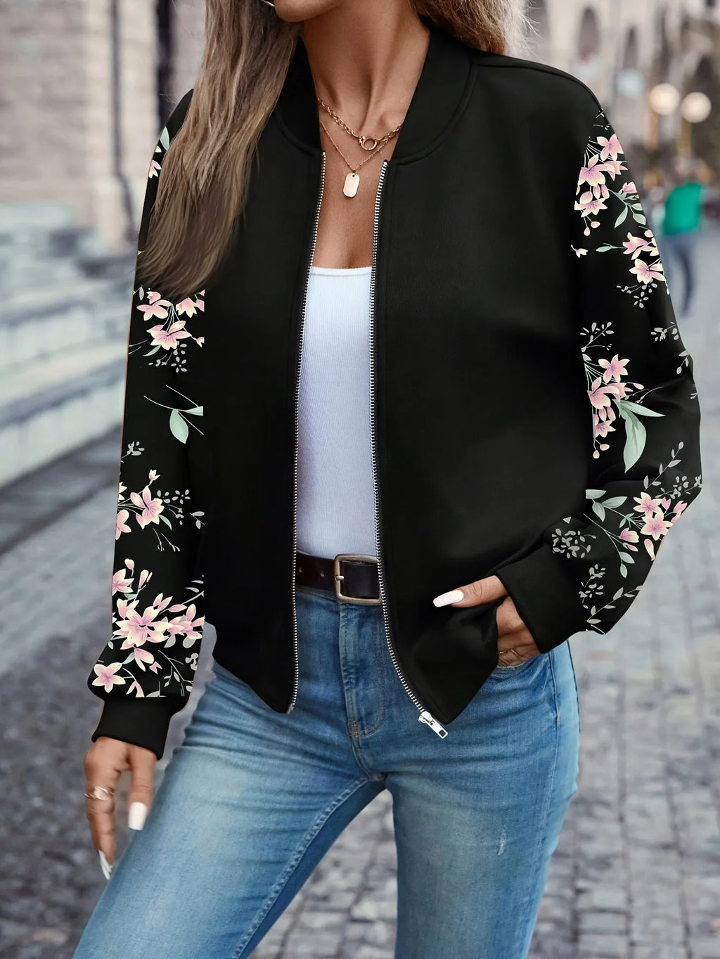 Close-up of the bomber jacket's baseball collar, zip fastening and floral sleeve detail