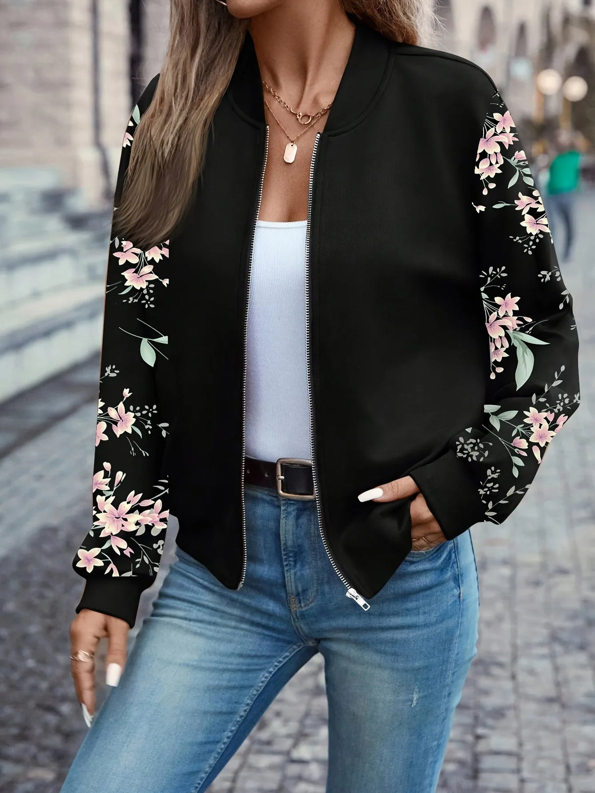 Close-up of the bomber jacket's baseball collar, zip fastening and floral sleeve detail