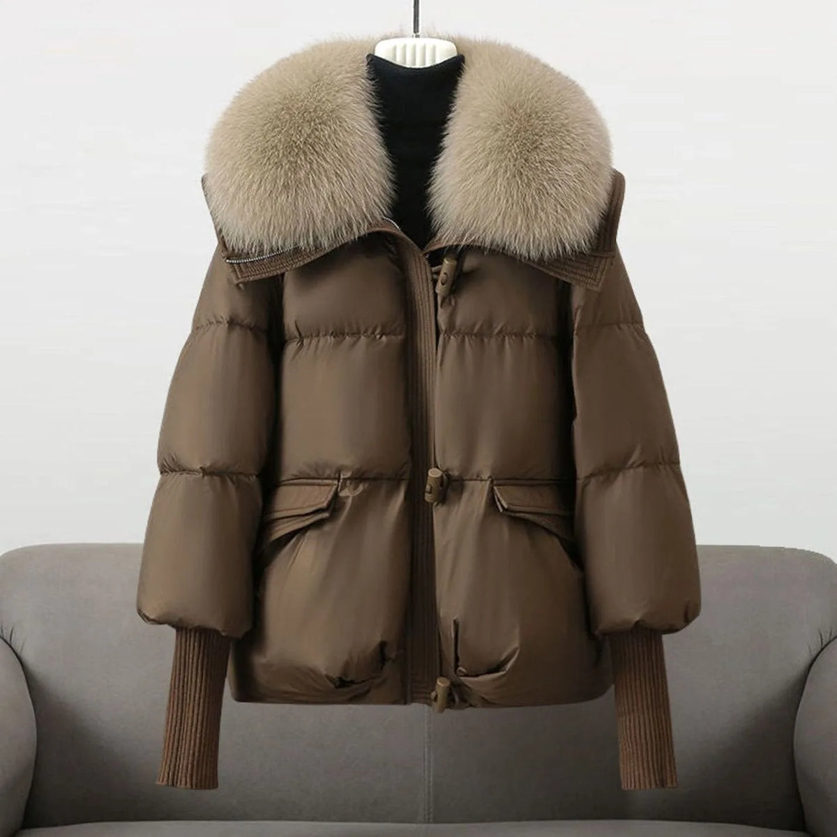 Brown cropped puffer jacket with a light taupe fur collar, front pockets and toggle fastenings visible
