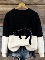 Black and white fuzzy jumper with a black cat silhouette appliqué outlined against the white hem