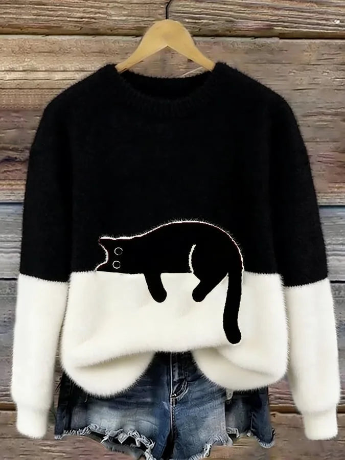 Black and white fuzzy jumper with a black cat silhouette appliqué outlined against the white hem