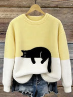 Pale yellow and cream fluffy jumper showing the black cat appliqué at the front hemline