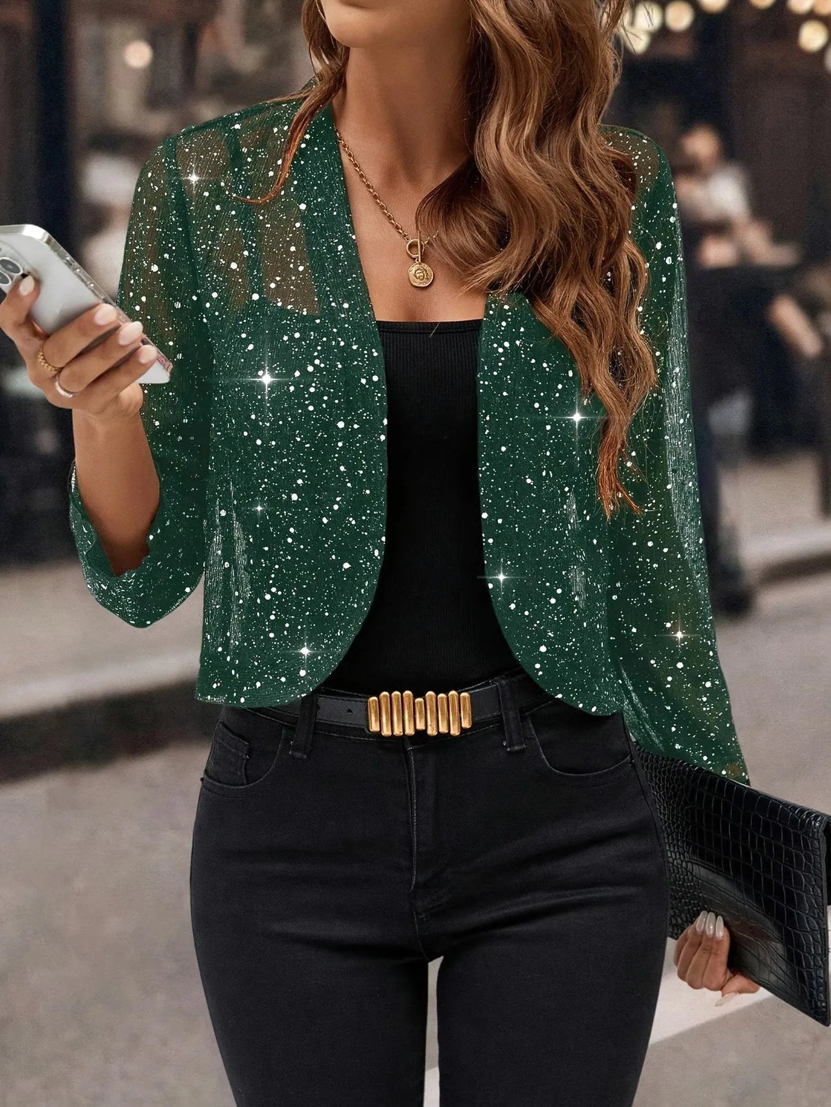 Green sequin cropped cardigan jacket with sheer sparkle finish styled over a black top and denim