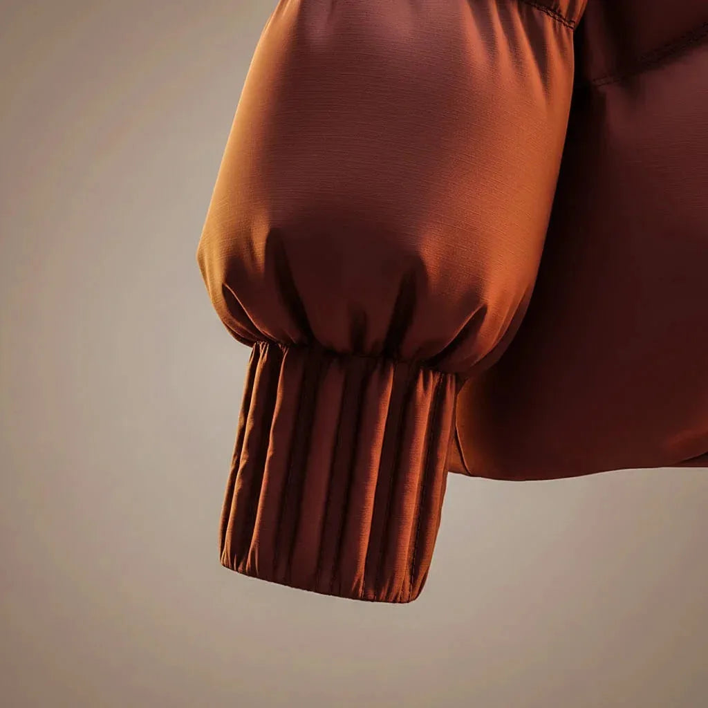 Close-up of the ribbed knit cuff on the sleeve of the glossy quilted jacket