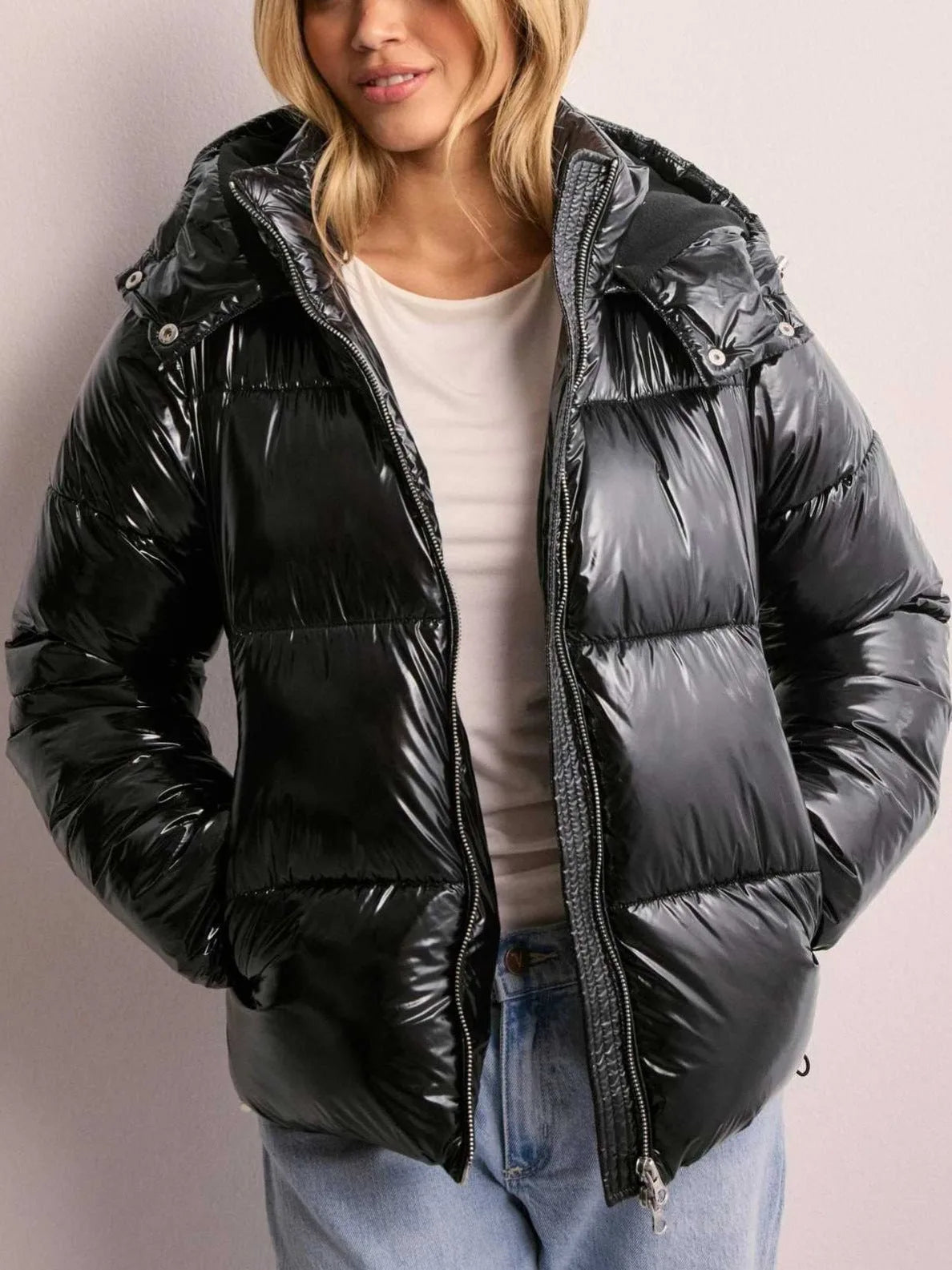 Front view of the black puffer jacket fully zipped with hood up, showing the quilted horizontal panel construction