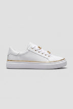 Side view of white trainer with gold chain-link lace detail and slim gold trim along the white flatform sole