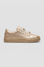 Side view of a gold metallic trainer with matching gold chain-link laces and a gold flatform sole
