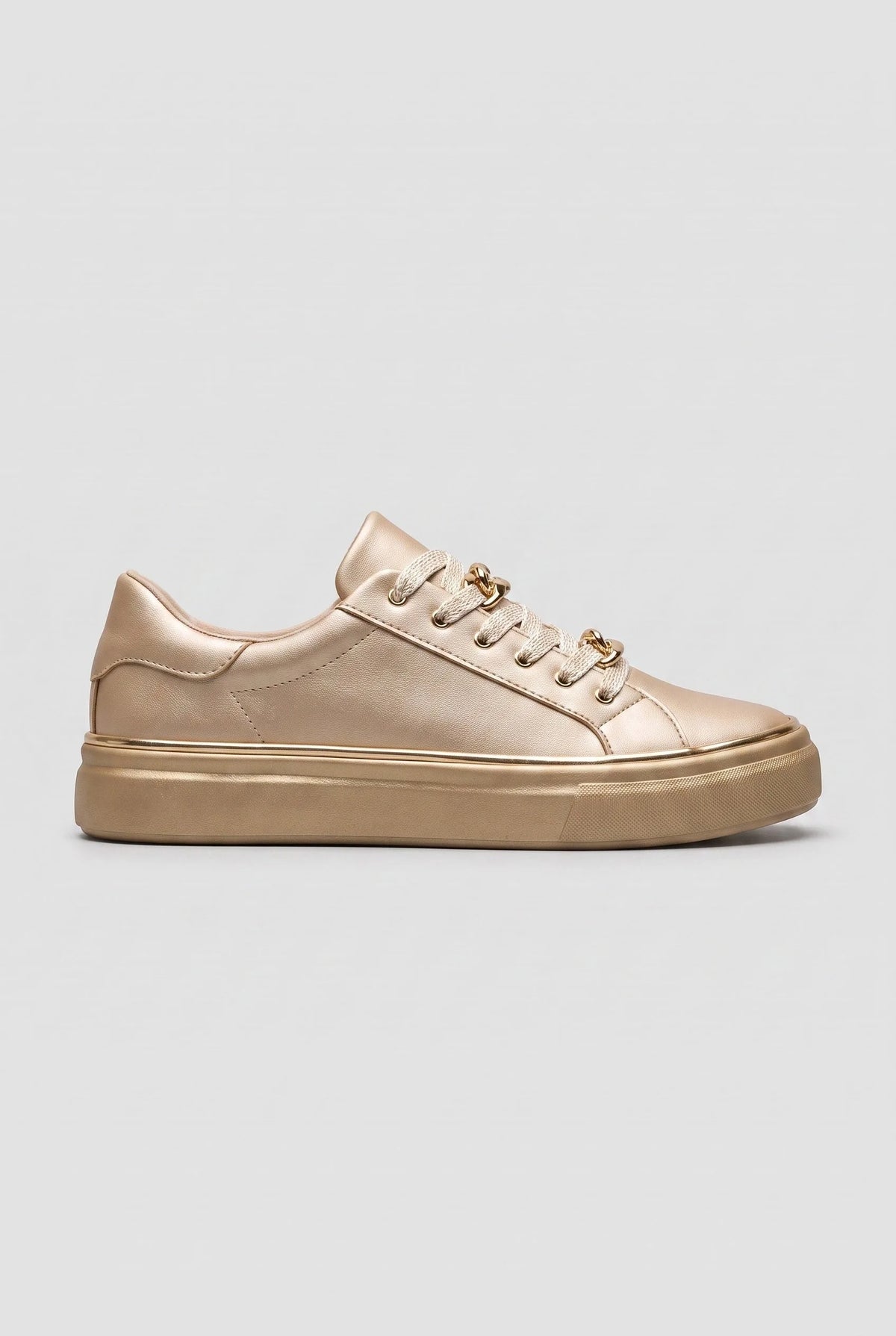 Side view of a gold metallic trainer with matching gold chain-link laces and a gold flatform sole