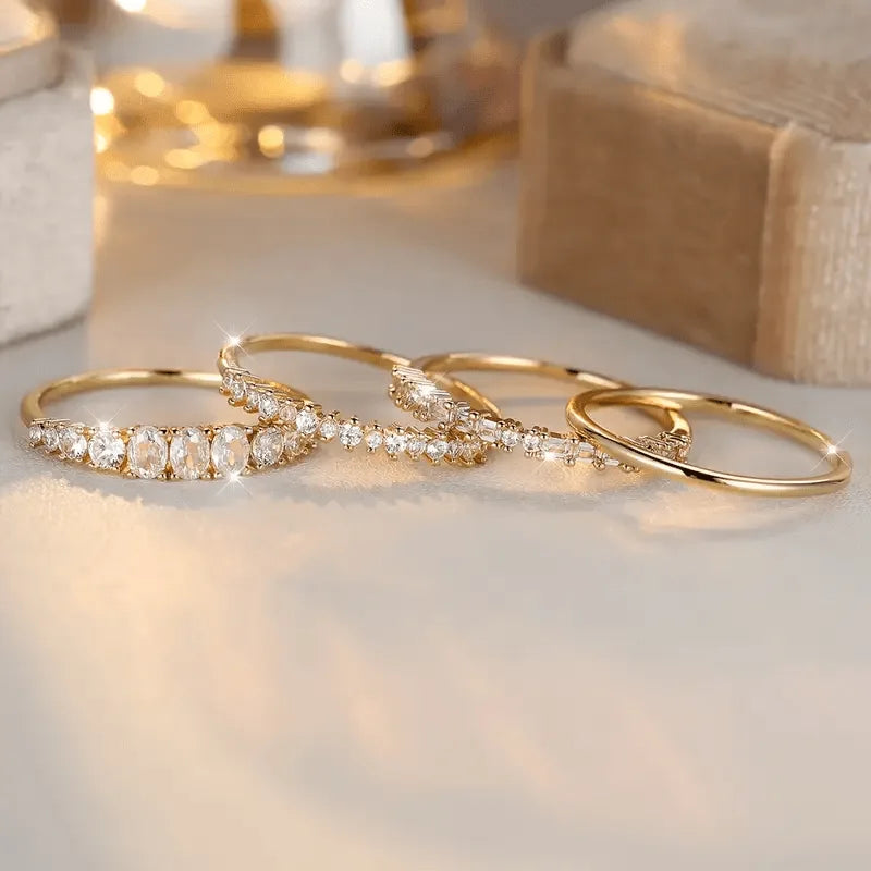 Close-up of the same gold stacking ring set laid flat, showing oval, baguette and pave crystal detailing