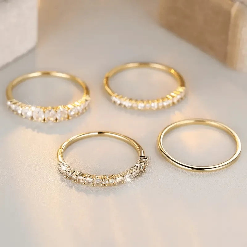 Overhead view of the four rings arranged in a row, highlighting the plain band and two crystal-studded designs
