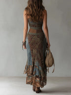 Back view of the asymmetric maxi dress showing the fitted waist seam, ruffled tiered skirt and floor-sweeping length.