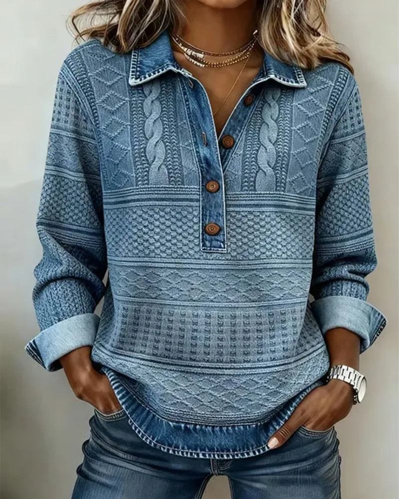 Close-up of blue denim-effect collar with brown buttons on a cable-knit textured jumper, worn open at the neck