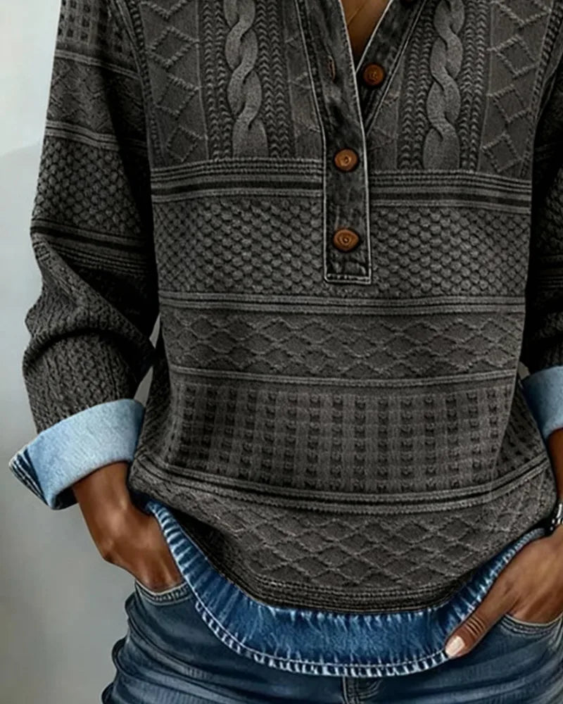 Front detail of charcoal grey textured jumper with denim collar, rolled cuffs and hands tucked into jean pockets