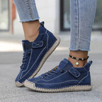 Navy suede trainers with contrast stitching and elastic side strap paired with denim jeans