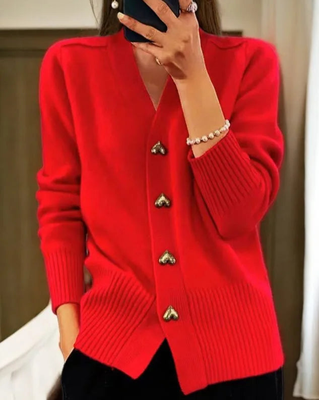 Red V-neck cardigan with gold heart buttons down the front, shown with ribbed sleeve cuffs