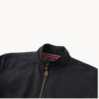Close-up of black jacket collar and double-button neck fastening with tartan trim visible inside