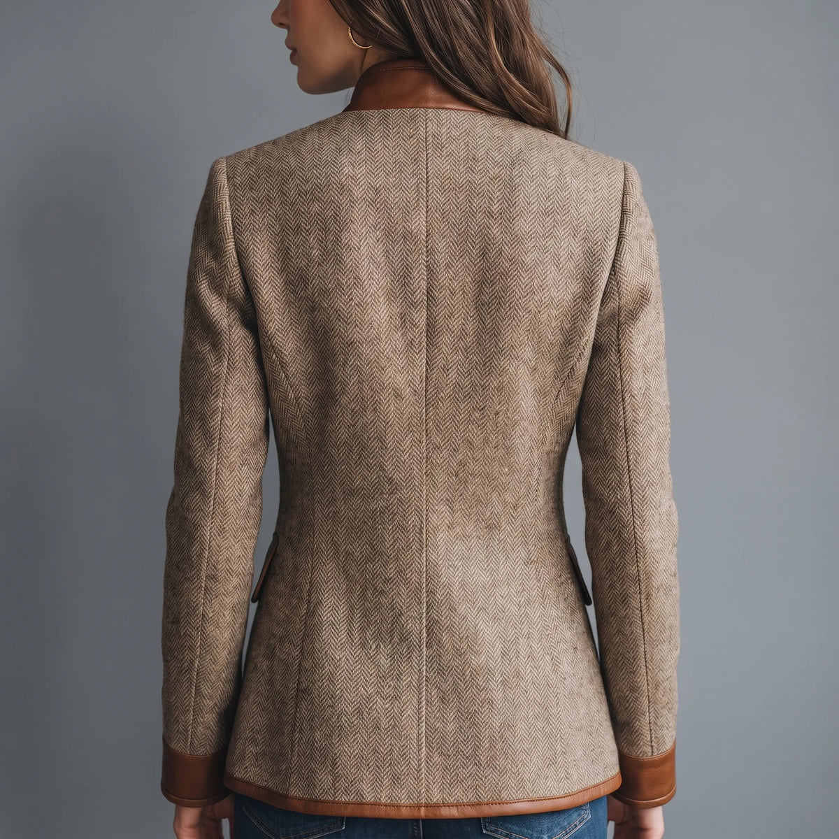 Back view of the tailored tweed jacket, showing the fitted waist shaping and leather-trimmed cuffs