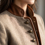 Close-up of the stand collar with tan leather edging and bronze-tone buttons down the front