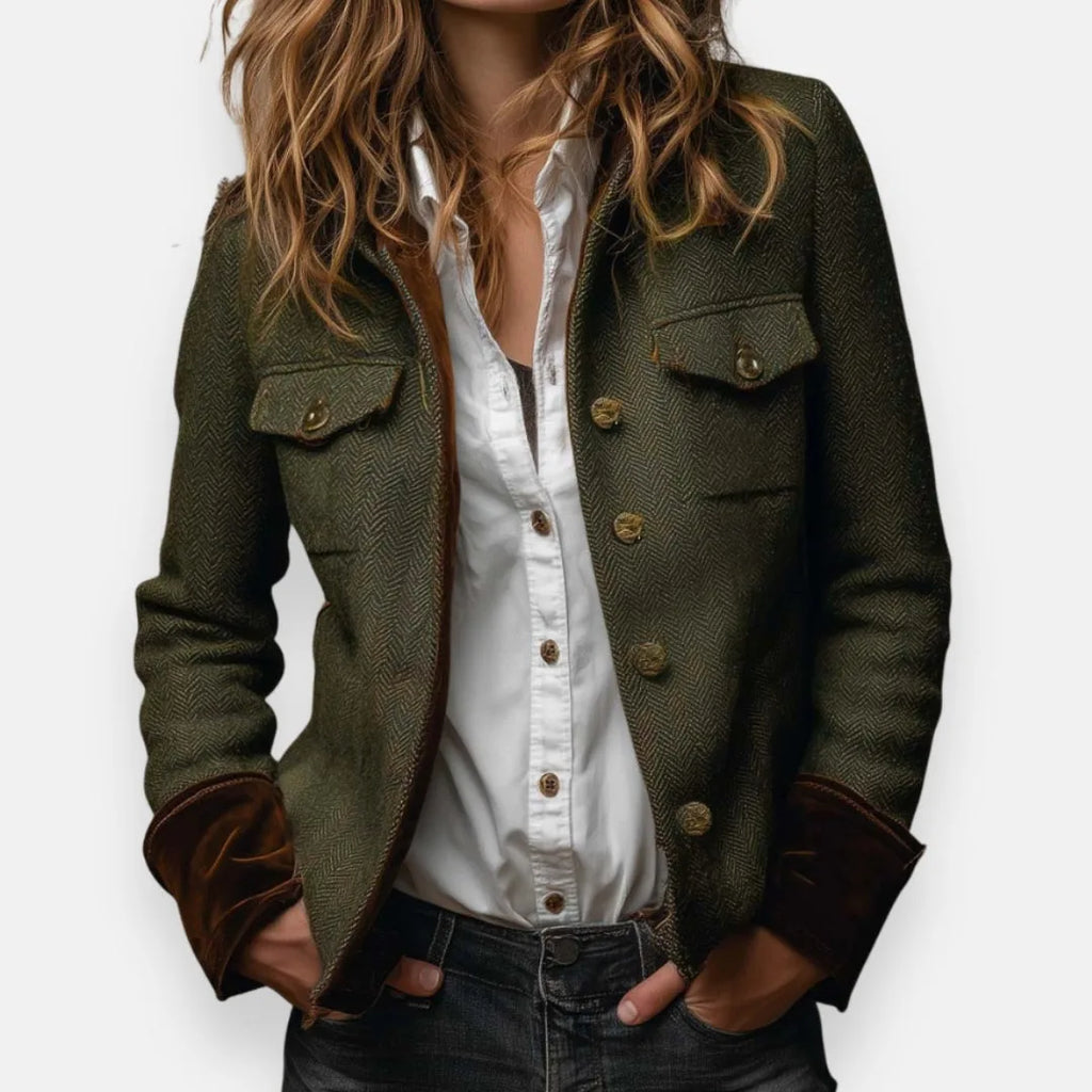 Woman modelling an olive herringbone tweed jacket with brown contrast cuffs over a white shirt