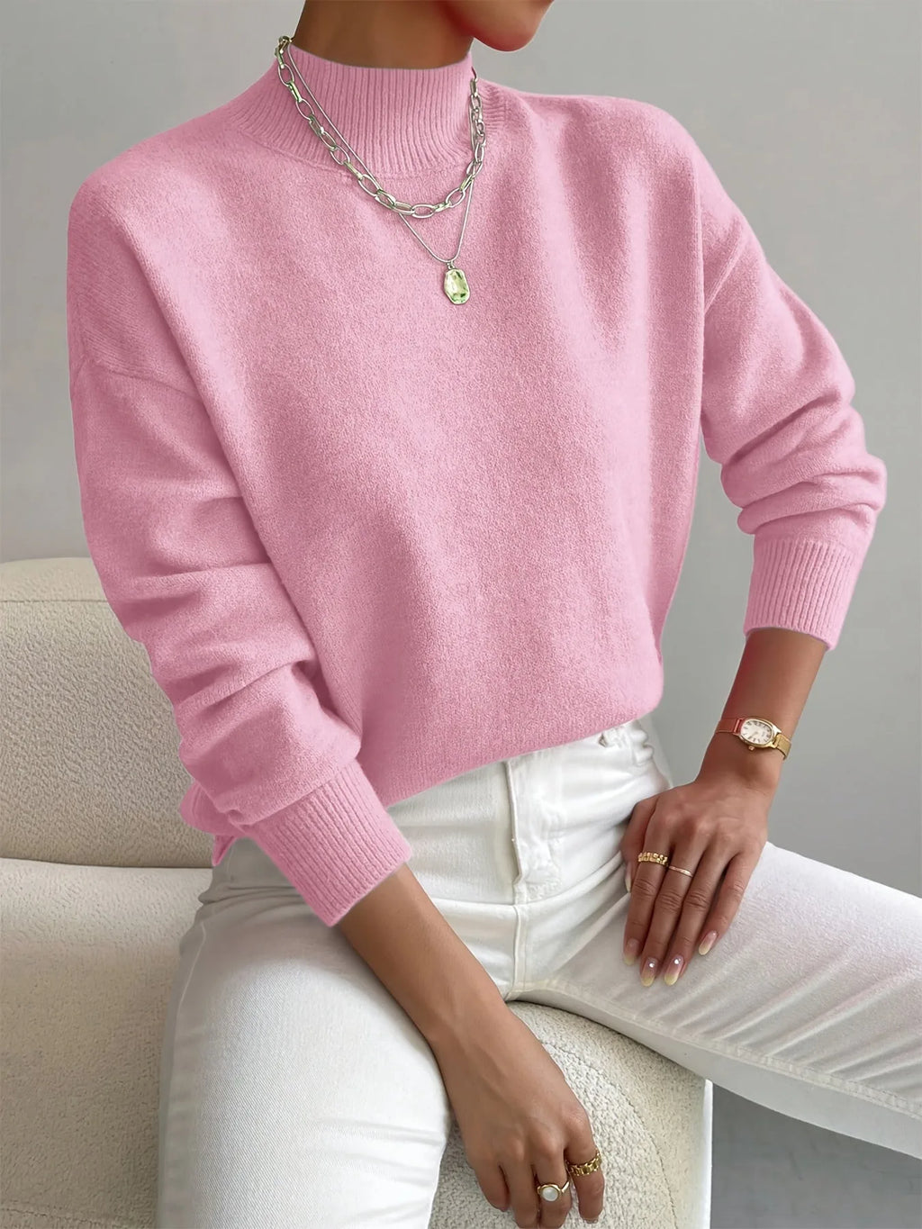 Light pink high neck jumper with ribbed cuffs, paired with silver chain necklace and white denim.