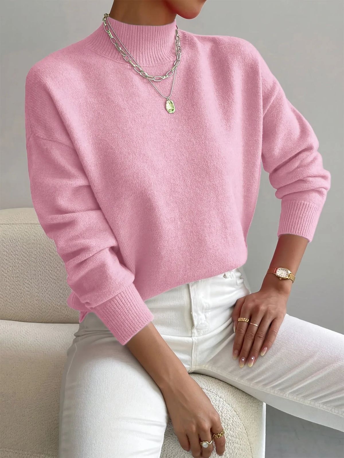 Light pink high neck jumper with ribbed cuffs, paired with silver chain necklace and white denim.