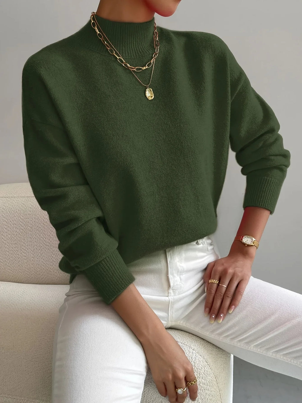 Olive green high neck jumper with relaxed oversized sleeves and ribbed mock collar detail.