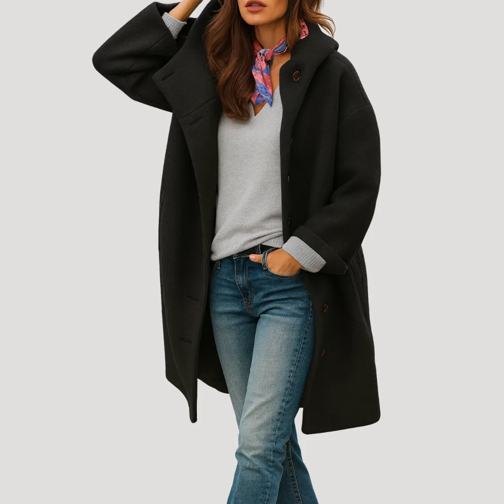Black hooded longline coat with wooden buttons, shown styled with a grey jumper and a printed scarf