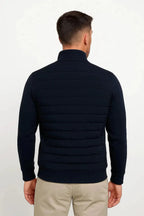 Back view of the navy jacket showing the quilted panel construction and ribbed knit sleeves
