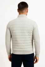 Back view of the light grey jacket highlighting the quilted back panel and knitted sleeve detail