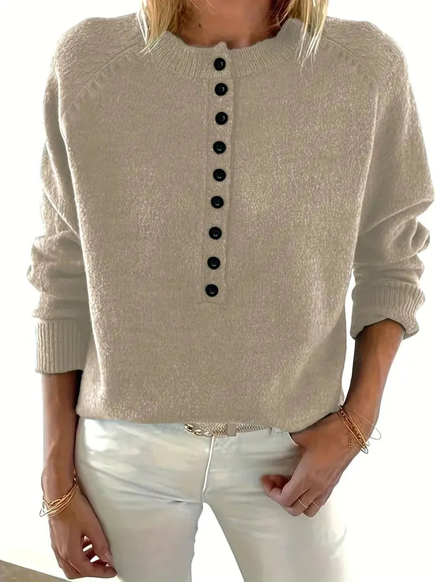 Front view of a beige knit jumper showing the relaxed silhouette and dropped shoulder seams