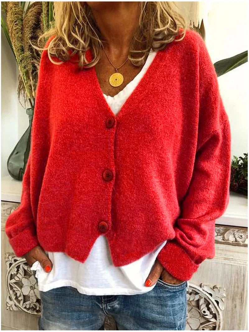 Red knitted button-up cardigan with long sleeves and a relaxed V-neck, layered over a white tee