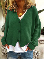Dark green knitted cardigan with a soft V-neckline, buttoned front and long sleeves, worn with jeans