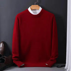 Deep red knitted jumper with white contrast collar and ribbed cuffs, displayed on a wooden hanger