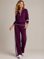 Front view of a deep purple quarter-zip knit set with white stripe detailing on cuffs, waistband and trouser sides