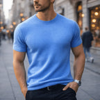 Man wearing a sky blue short-sleeve knitted tee with ribbed collar, paired with dark trousers and a belt