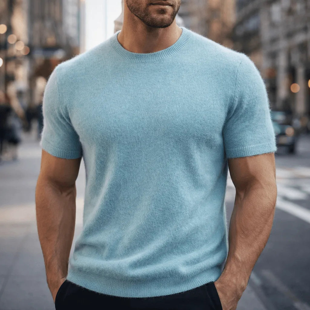 Close-up front view of a pale blue knitted tee showing the ribbed crew neckline and soft fuzzy texture