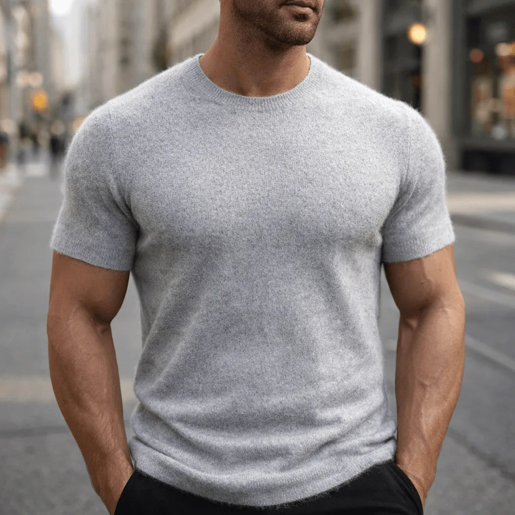 Man wearing a light grey short-sleeve knitted tee with visible ribbed sleeve cuffs and crew neckline
