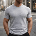 Man wearing a light grey short-sleeve knitted tee with visible ribbed sleeve cuffs and crew neckline