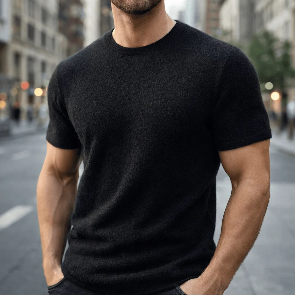 Man wearing a black short-sleeve knitted tee, close-up view showing the soft knit texture and neckline