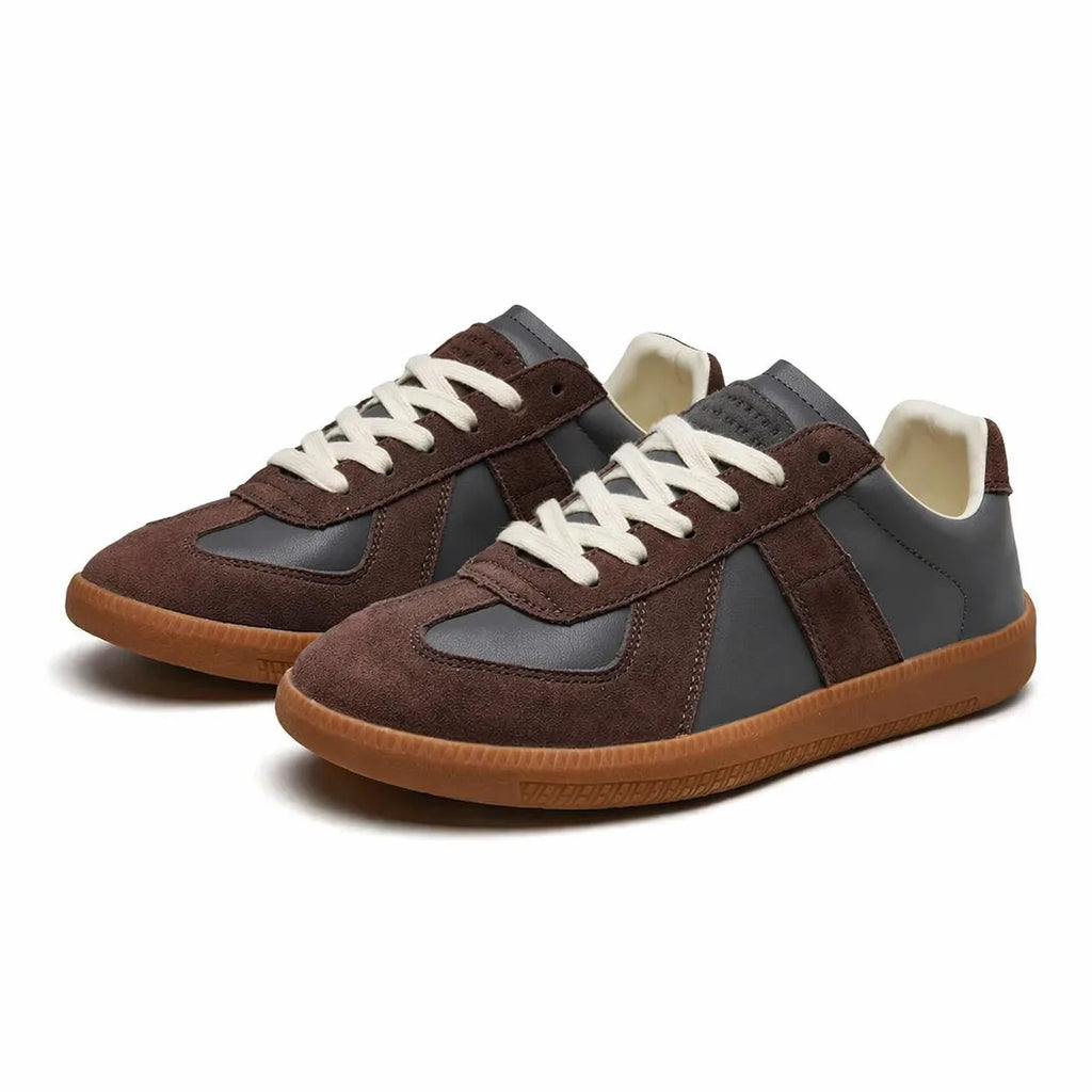 Front angled view of black and white colour-block trainers with cream laces and tonal gum sole