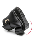 Sole and heel view of a black ankle boot showing the deep-grip wedge outsole and stacked heel construction
